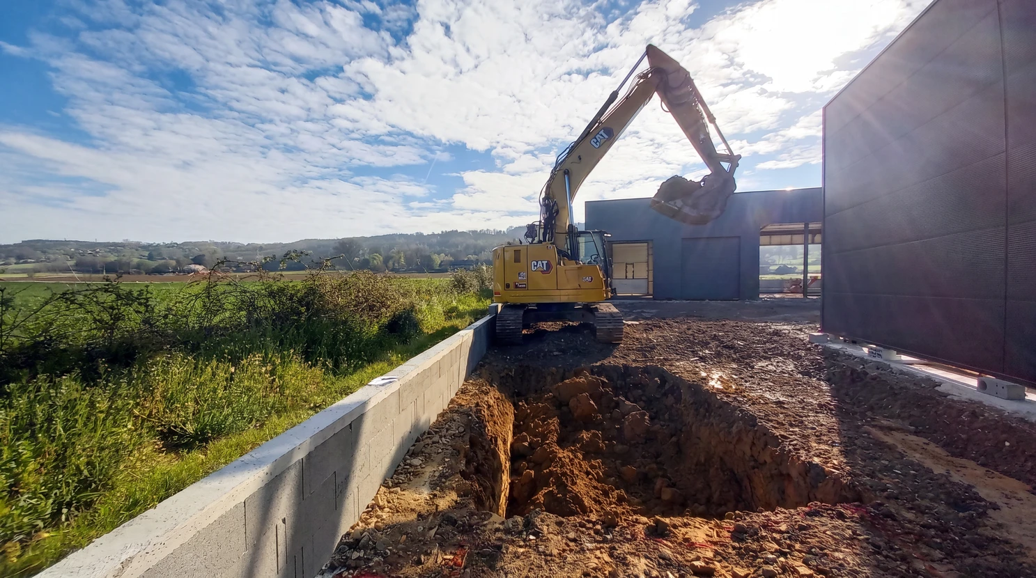Chantier de construction routière en extérieur avec ouvriers en gilets de sécurité orange haute visibilité travaillant sur pose de bordures béton