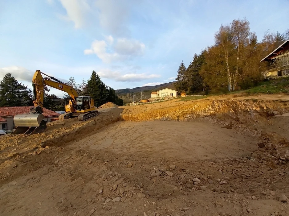 Chantier de terrassement en extérieur avec ouvriers en équipements de sécurité supervisant une excavatrice hydraulique dans une tranchée